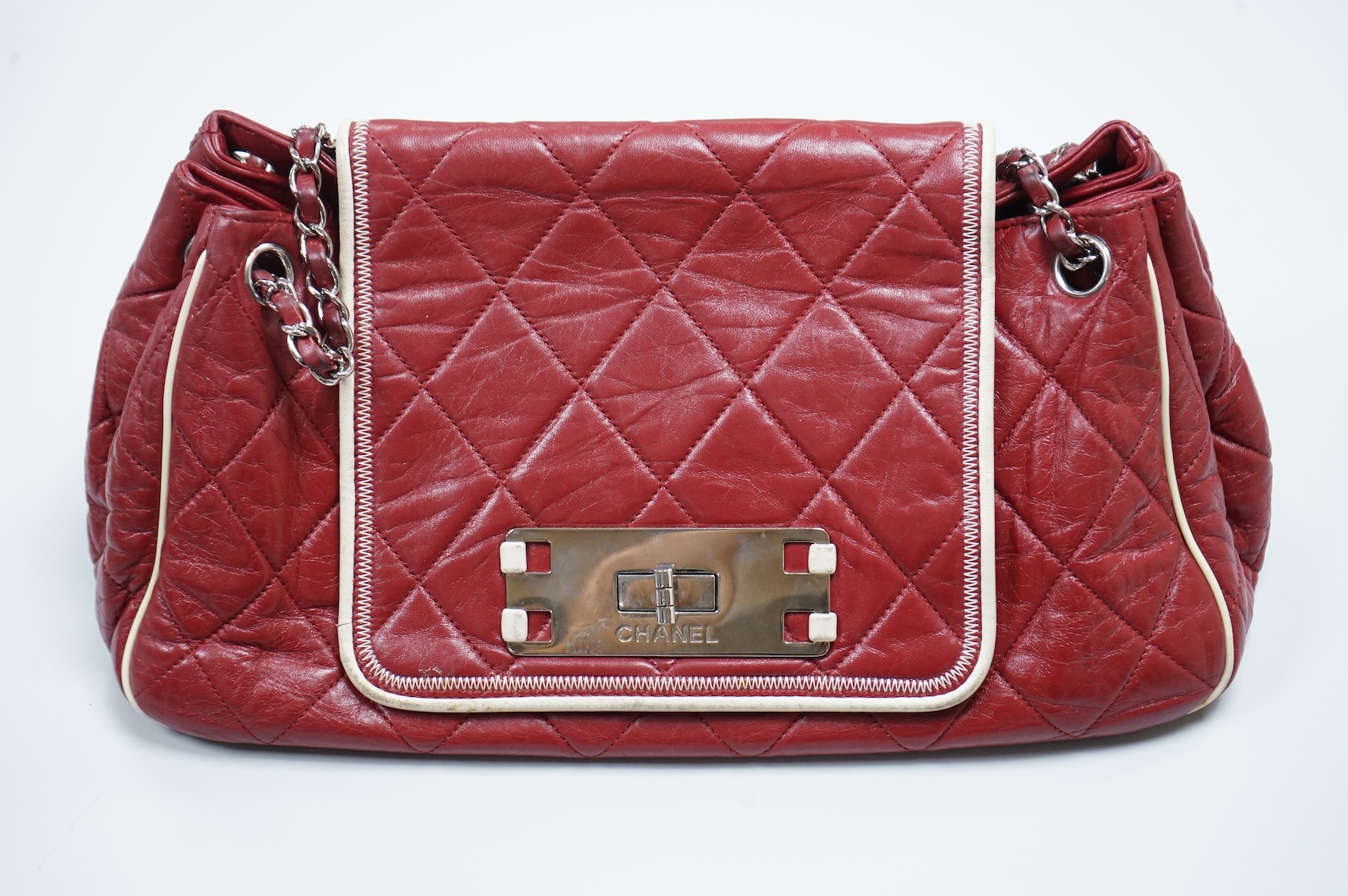 A Chanel East West dark red quilted leather flap shoulder bag with silver hardware, date code 12115484, with original receipt, dust cover and box, 35cm wide, Provenance: purchased by the vendor in Selfridges